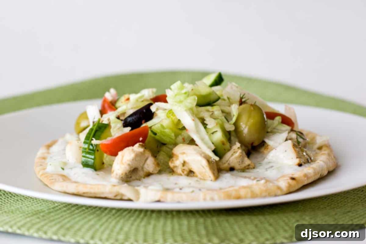 A beautifully plated Souvlaki: Chicken Shish Kebab, showcasing the tender chicken, fresh salad, and creamy tzatziki on pita bread.