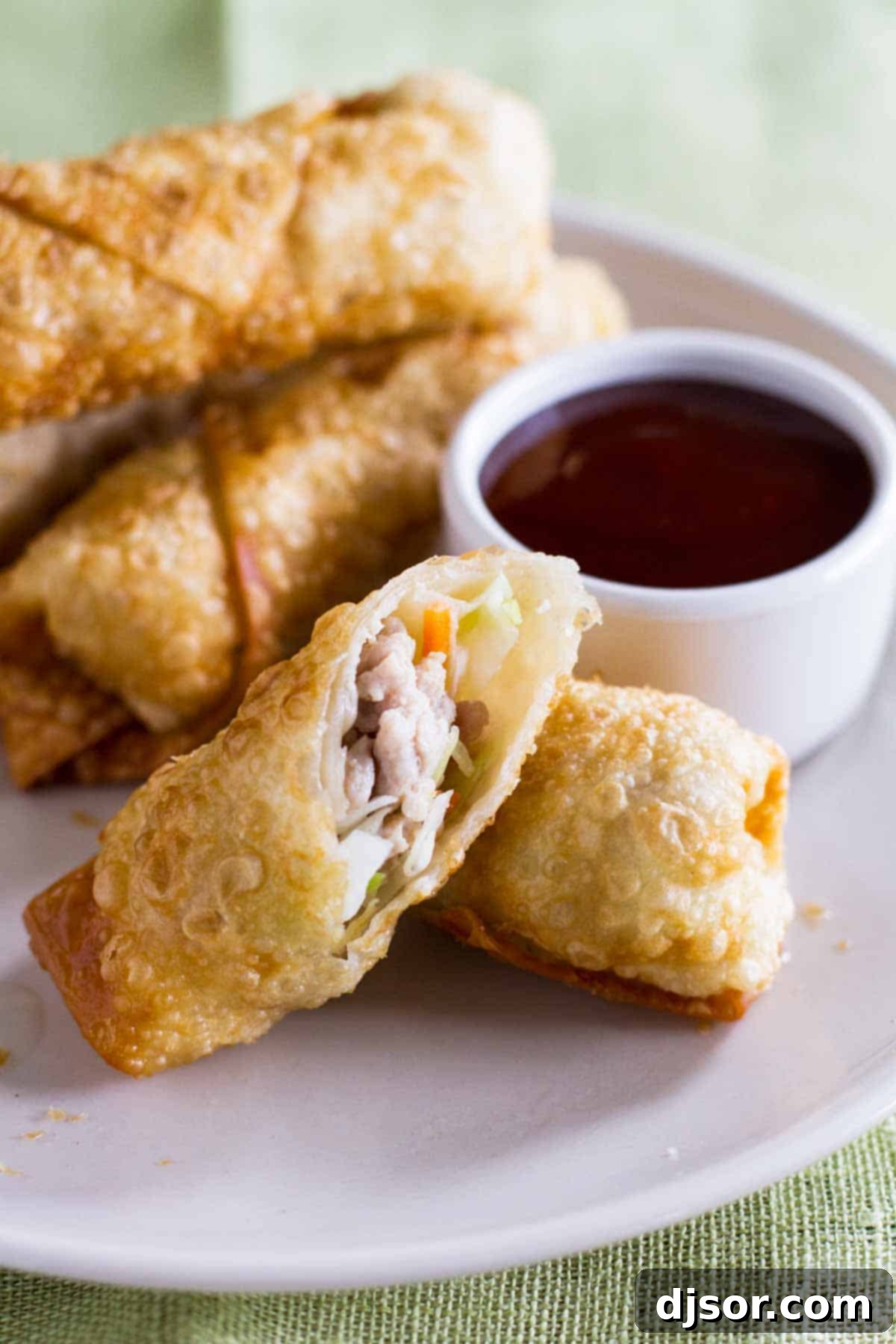 Looking for a go-to egg roll recipe? This Easy Egg Roll Recipe is simple and will rival the egg rolls from your local take out restaurant. Egg rolls cut to show interior.