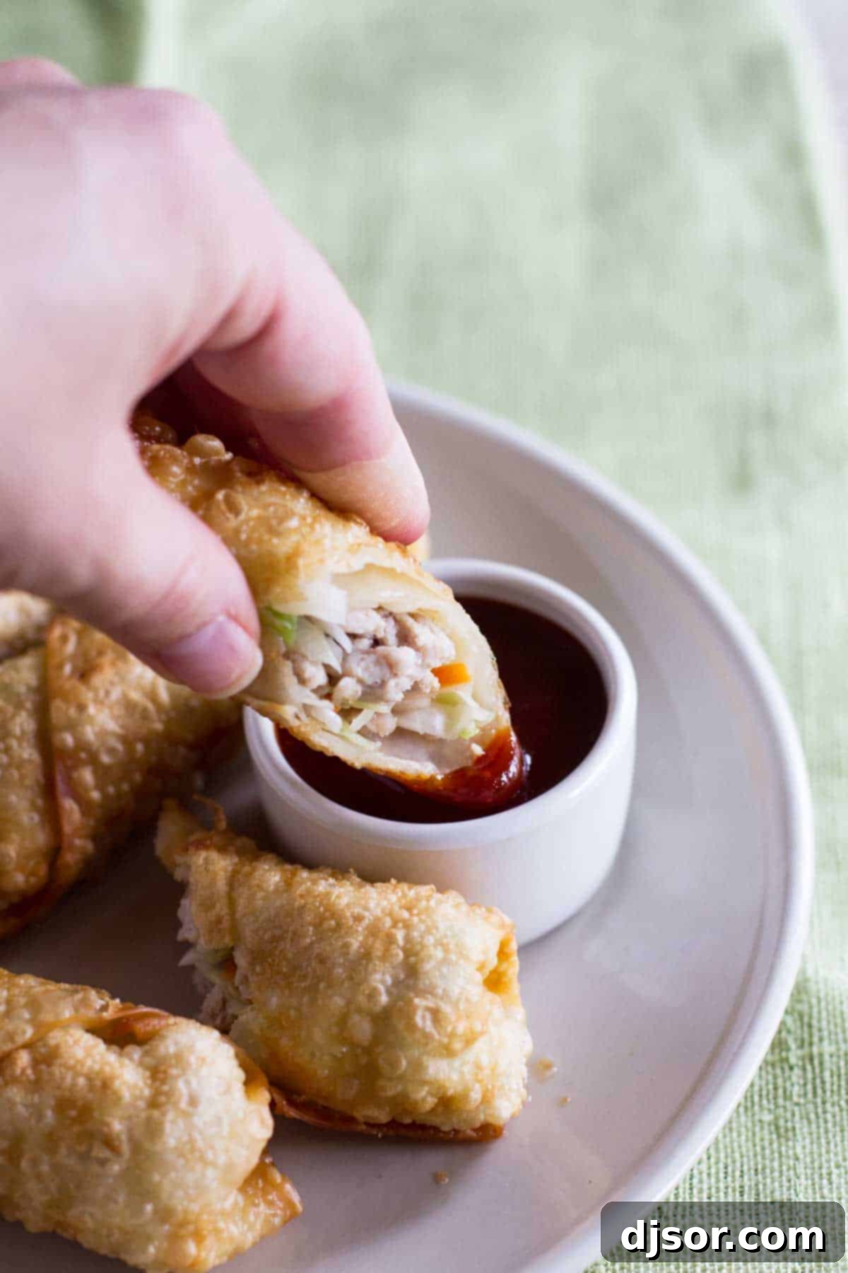 Crispy Homemade Egg Rolls 3 Dipping an egg roll into sweet and sour sauce.