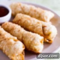 Crispy Homemade Egg Rolls 4 homemade egg rolls on a plate with sweet and sour sauce