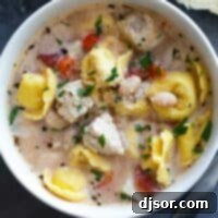 Hearty Chicken Tortellini Soup 2 A cozy bowl of Chicken Tortellini Soup, topped with Parmesan cheese and a hint of fresh herbs, presented in a clean, inviting style for a recipe card.