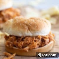 Easy Slow Cooker BBQ Pulled Chicken 2 Crockpot BBQ Pulled Chicken on a hamburger bun.
