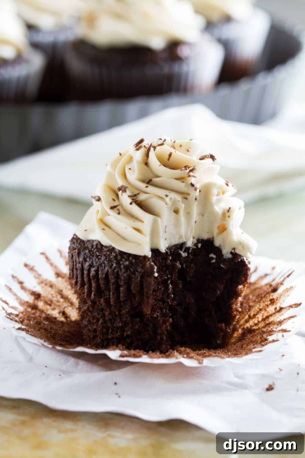 The best cream cheese frosting ever, this Whipped Cream Cheese Frosting adds a lightness to your typical cream cheese frosting. This cupcake frosting is luxurious and smooth and completely irresistible! Whipped Cream Cream Cheese Frosting on a chocolate cupcake with a bite taken from it.