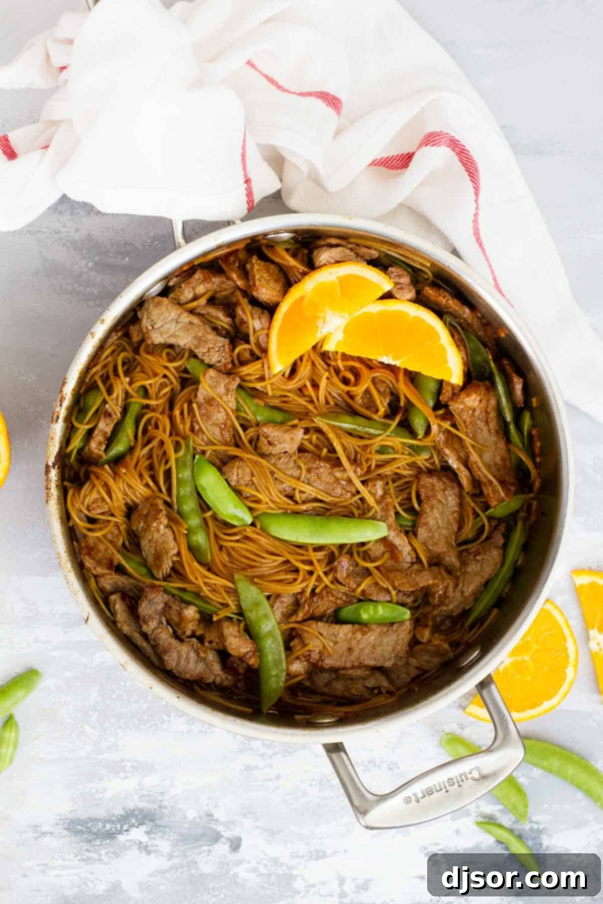 Orange Teriyaki Beef with Noodles simmering in a stainless steel pot, showcasing the rich sauce and tender ingredients.