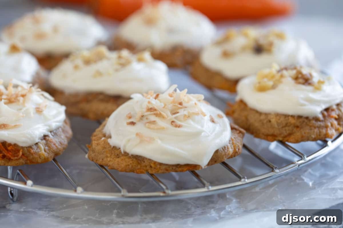 Carrot Cake Drops 2 Carrot Cake Cookies frosted with cream cheese on a cooling rack.