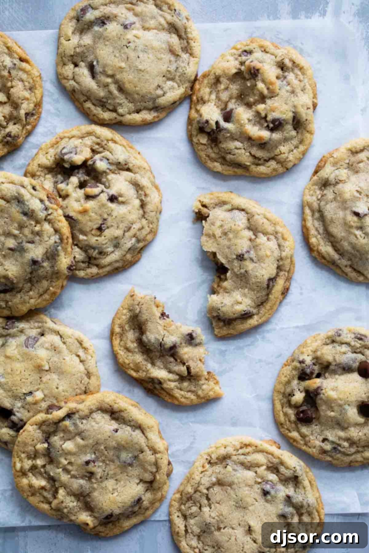 Doubletree Cookies, with one broken in half to show the gooey chocolate chips and walnuts inside. Golden brown edges and a soft, chewy center.