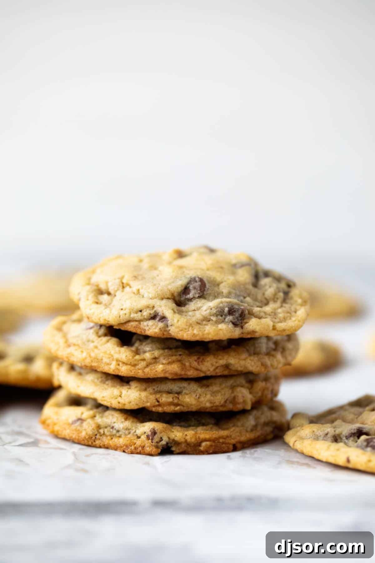 A stack of perfectly baked Doubletree Cookies, golden brown with visible chocolate chips and walnuts.