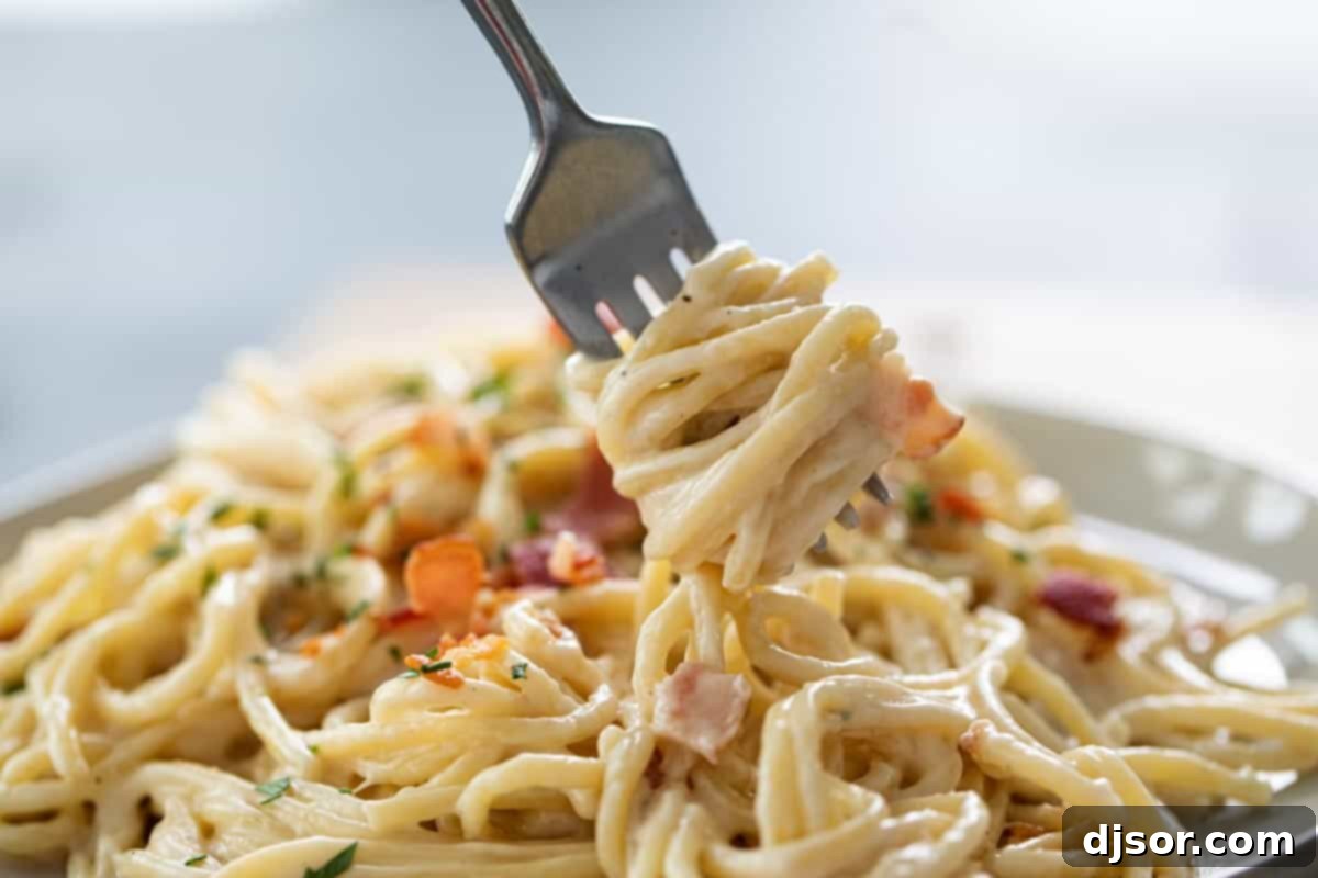 Alfredo Pasta with Bacon on fork