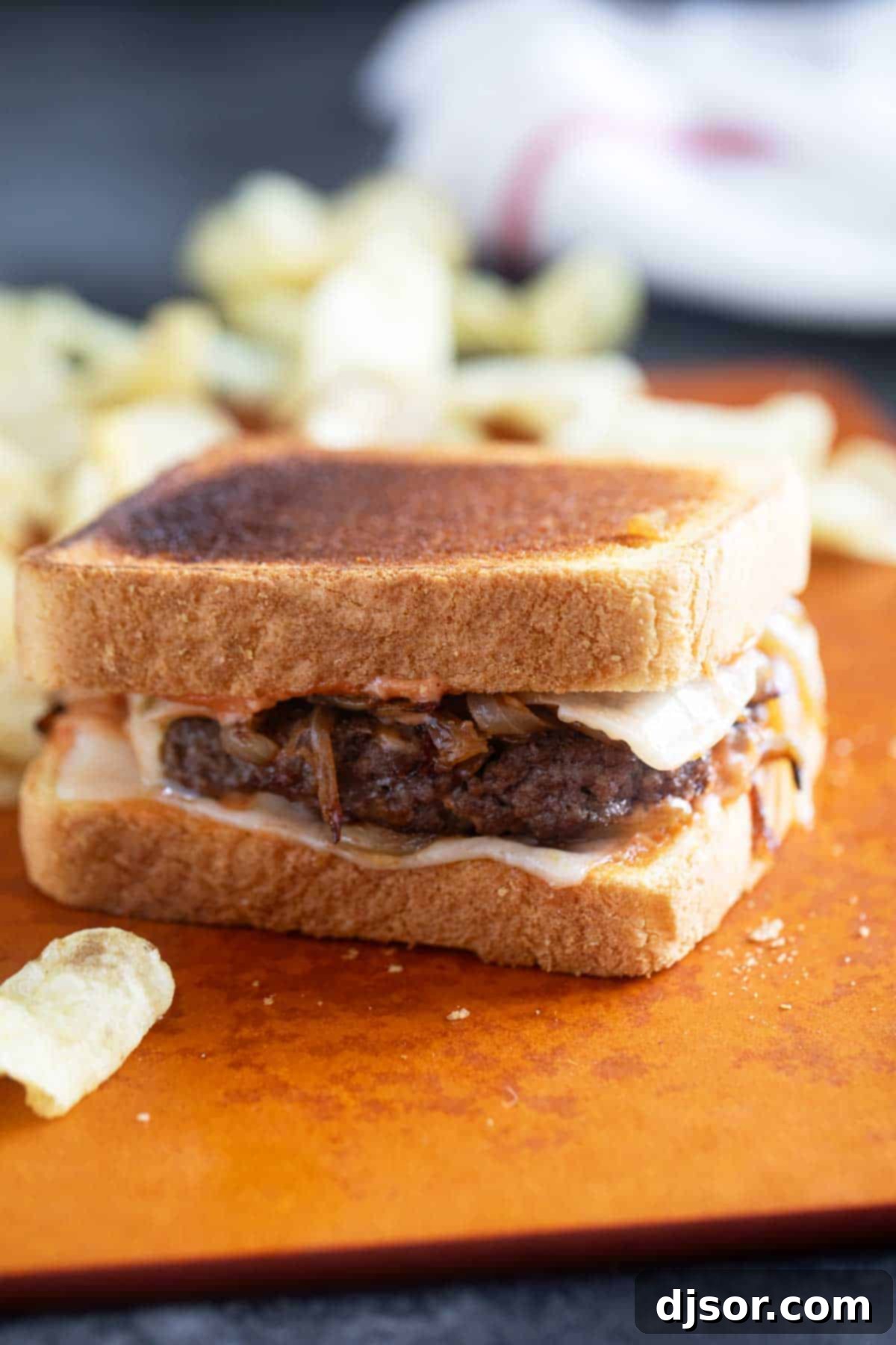 Classic Patty Melt 7 A freshly made Patty Melt with special sauce and caramelized onions, served alongside potato chips.