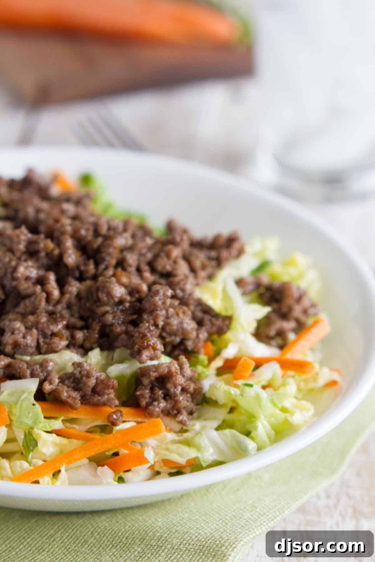 bowl filled with Asian Beef and Cabbage Salad, showcasing a colorful mix of seasoned ground beef, crisp Napa cabbage, and fresh vegetables