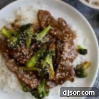 beef and broccoli sprinkled with sesame seeds over rice