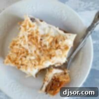 overhead view of slice of carrot sheet cake on a plate with a fork
