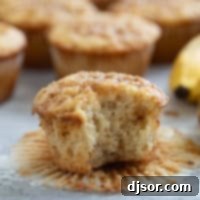 Banana Toffee Treat Muffins 10 A delicious Banana Toffee Muffin with a bite taken out, revealing its moist interior and scattered toffee pieces.