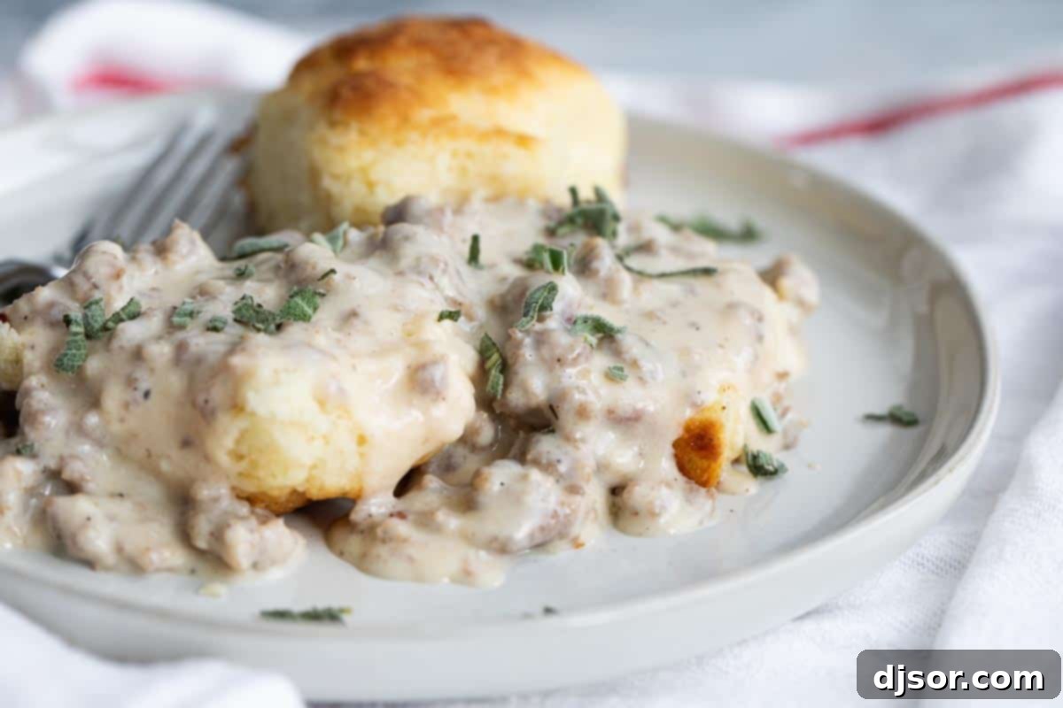 Hearty plate of homemade fluffy biscuits smothered in rich, savory sausage gravy.