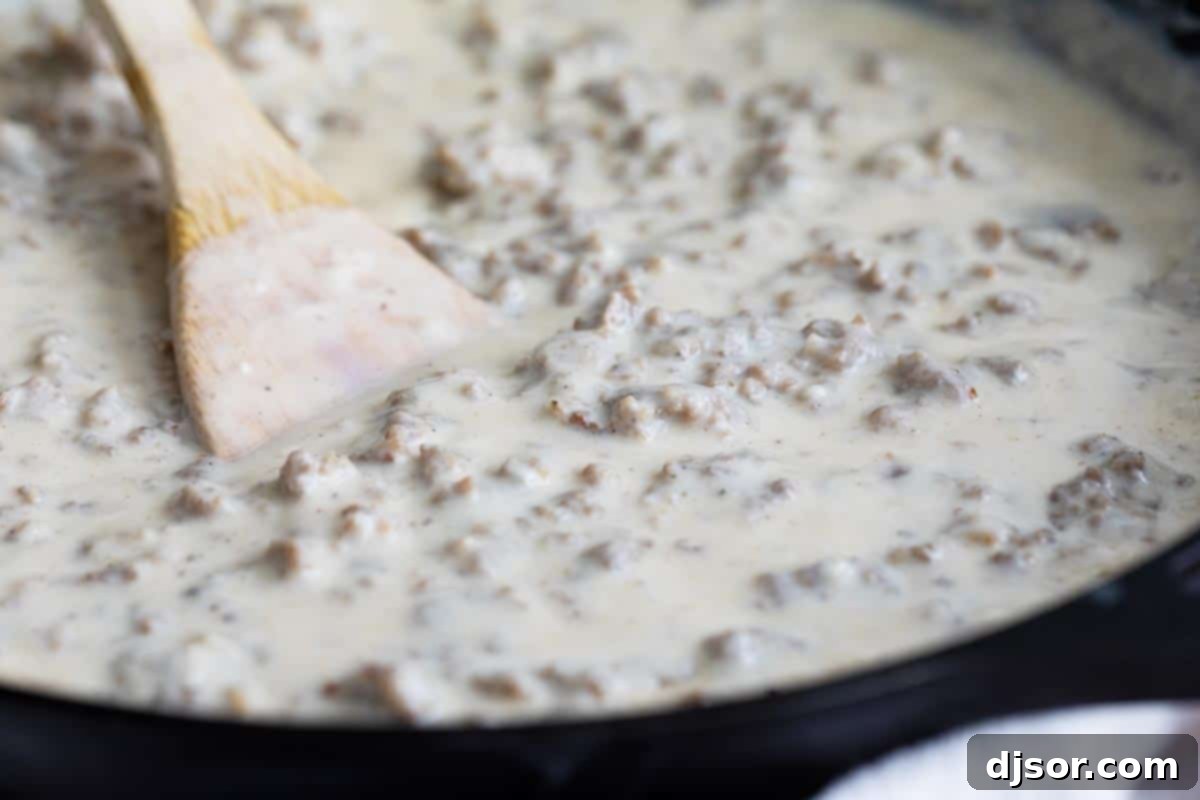 Homemade sausage gravy simmering to perfection in a rustic cast iron skillet.