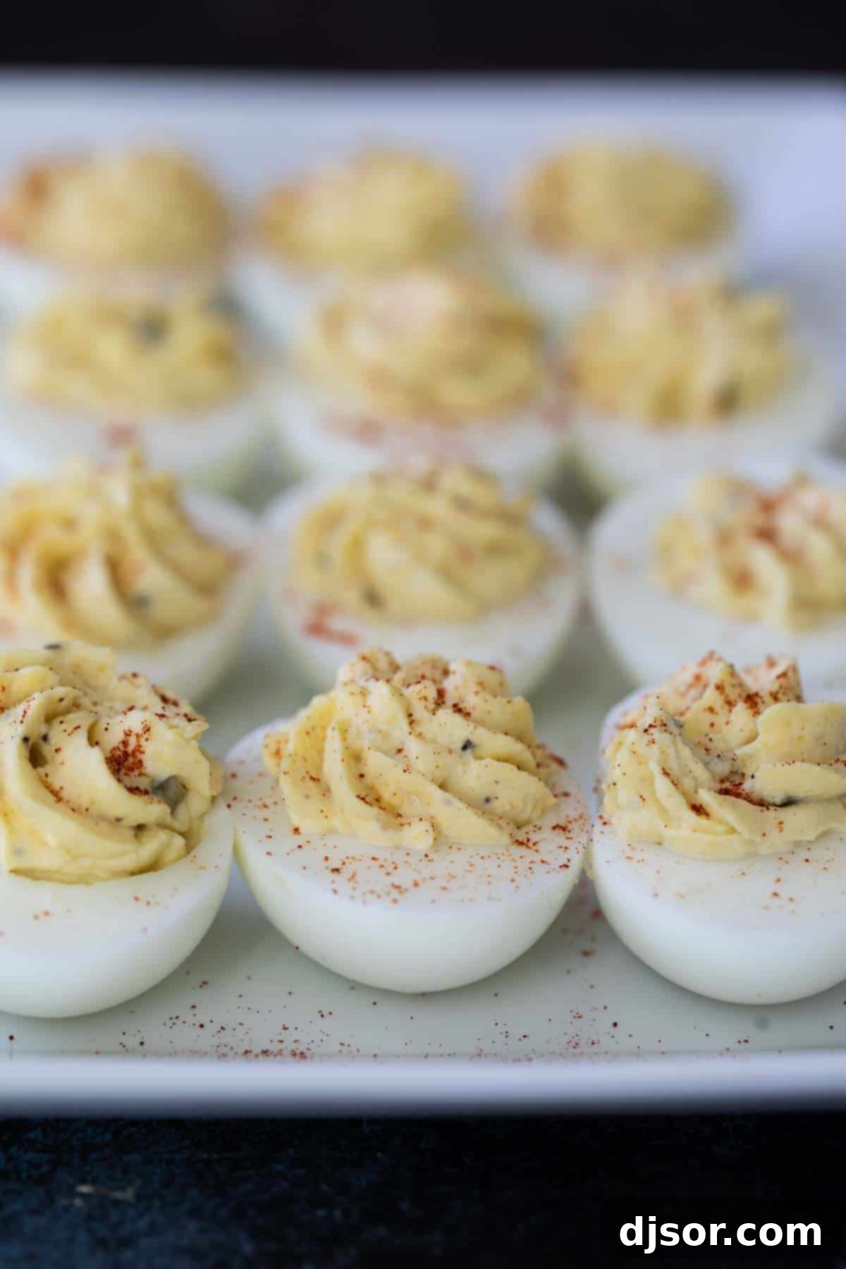 A plate of traditional deviled eggs, garnished with paprika and fresh chives, showcasing the classic appeal.