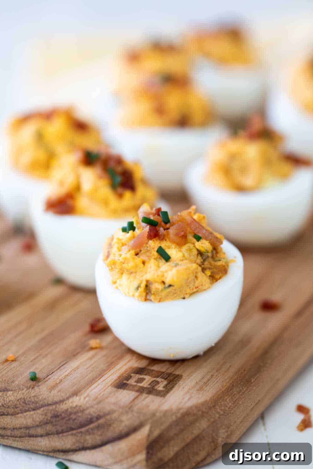 Close-up of deviled eggs garnished with crispy bacon bits, highlighting a savory and indulgent twist.