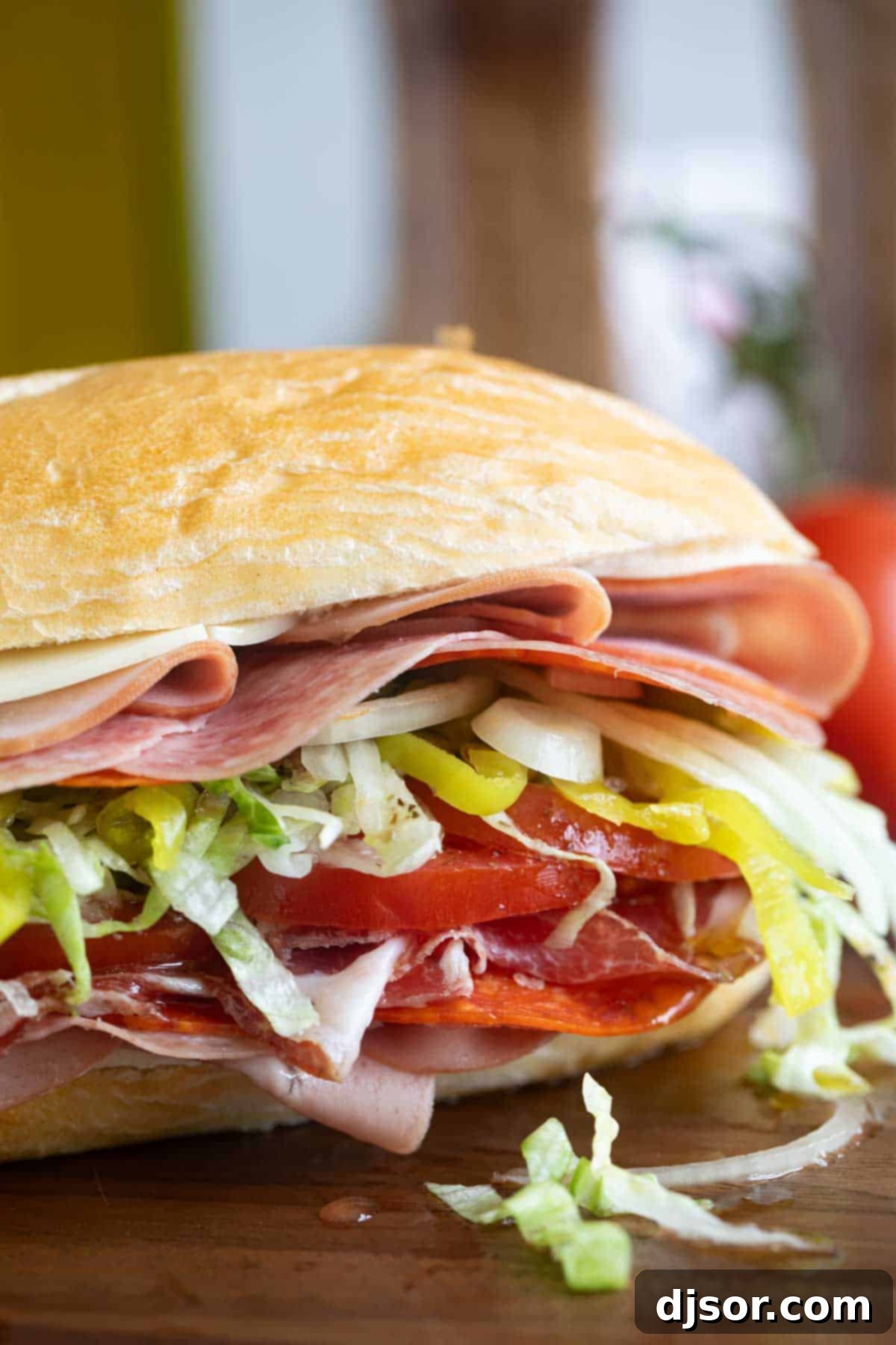 The Ultimate Italian Stack 7 A fully prepared and folded Italian Sub, showcasing its generous filling of meats, cheese, and vegetables, ready to be enjoyed.