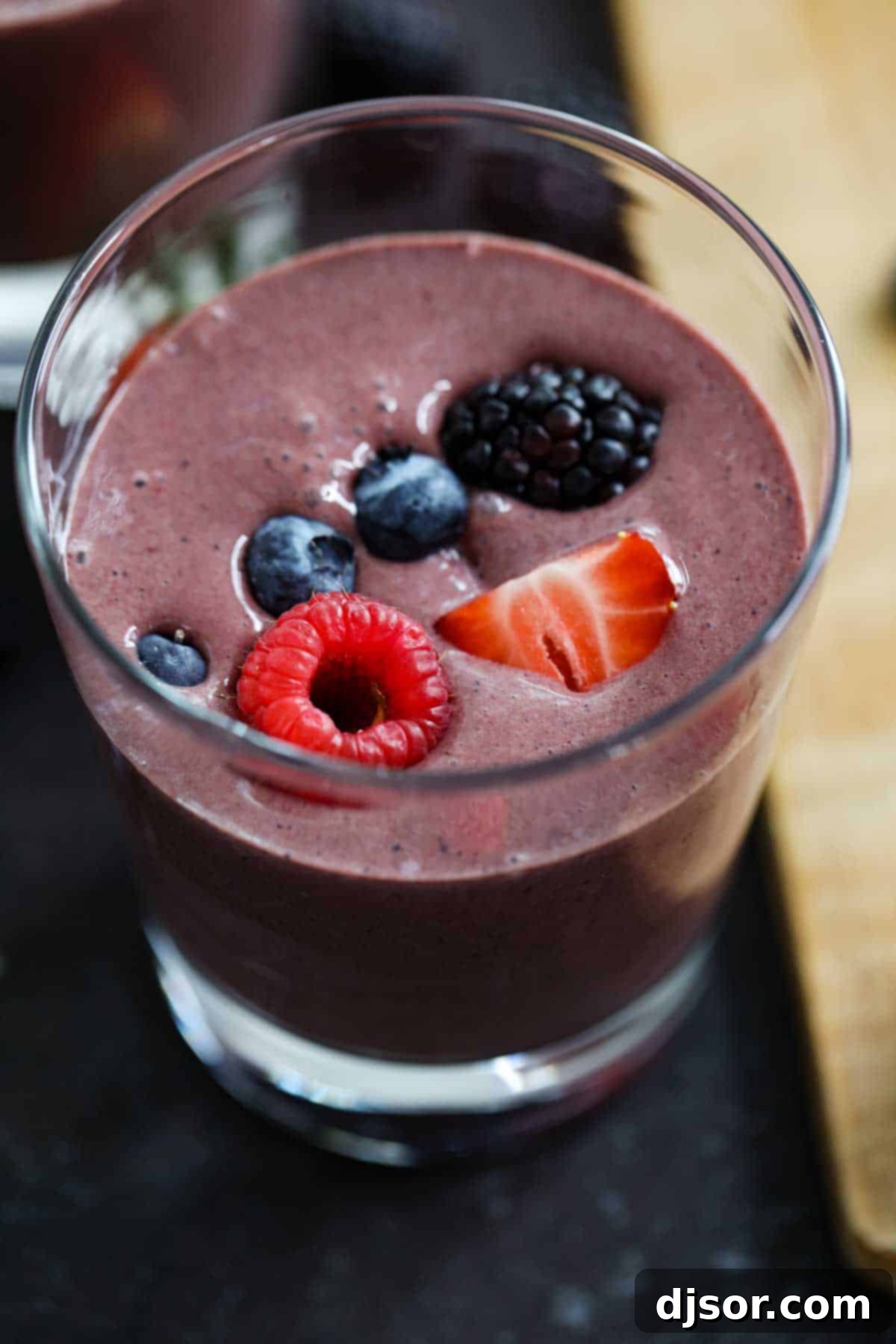 A vibrant berry smoothie recipe featuring a generous swirl of chocolate, ready to be poured.