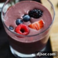 A beautifully presented berry smoothie recipe with chocolate swirls, garnished with fresh berries.