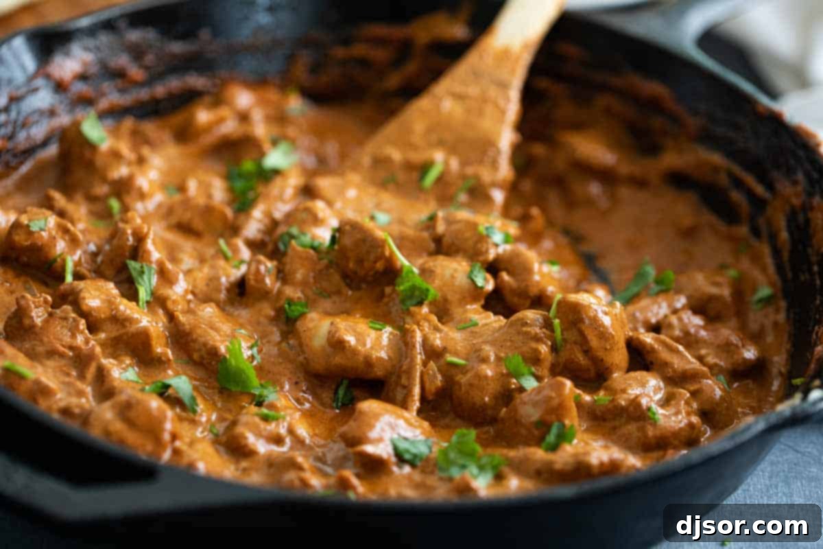 Butter Chicken simmering in a cast iron skillet, ready to serve