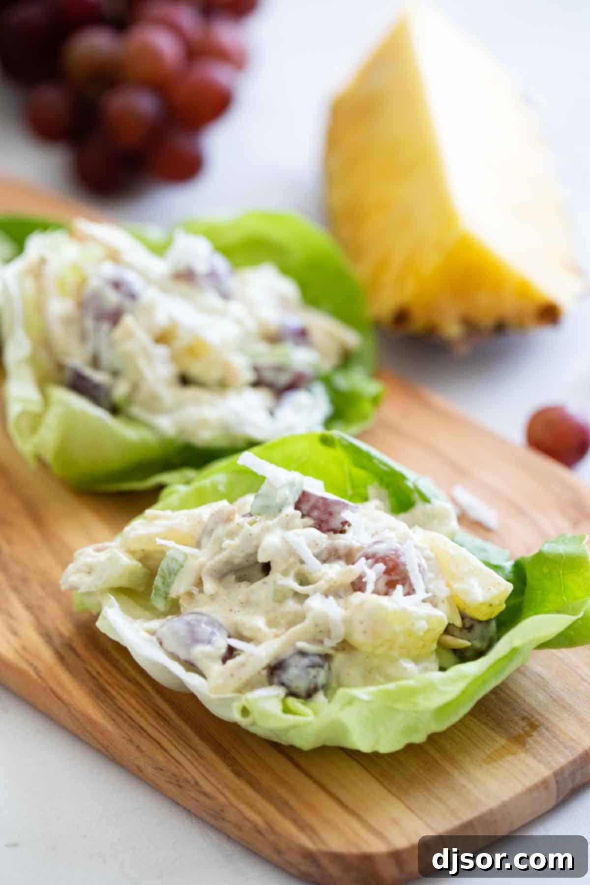 Chicken salad with an island twist - these Tropical Chicken Lettuce Wraps are filled with chicken, pineapple, grapes, and coconut with a creamy sauce to make the perfect perfect lettuce wraps. chicken lettuce wraps with tropical flavors