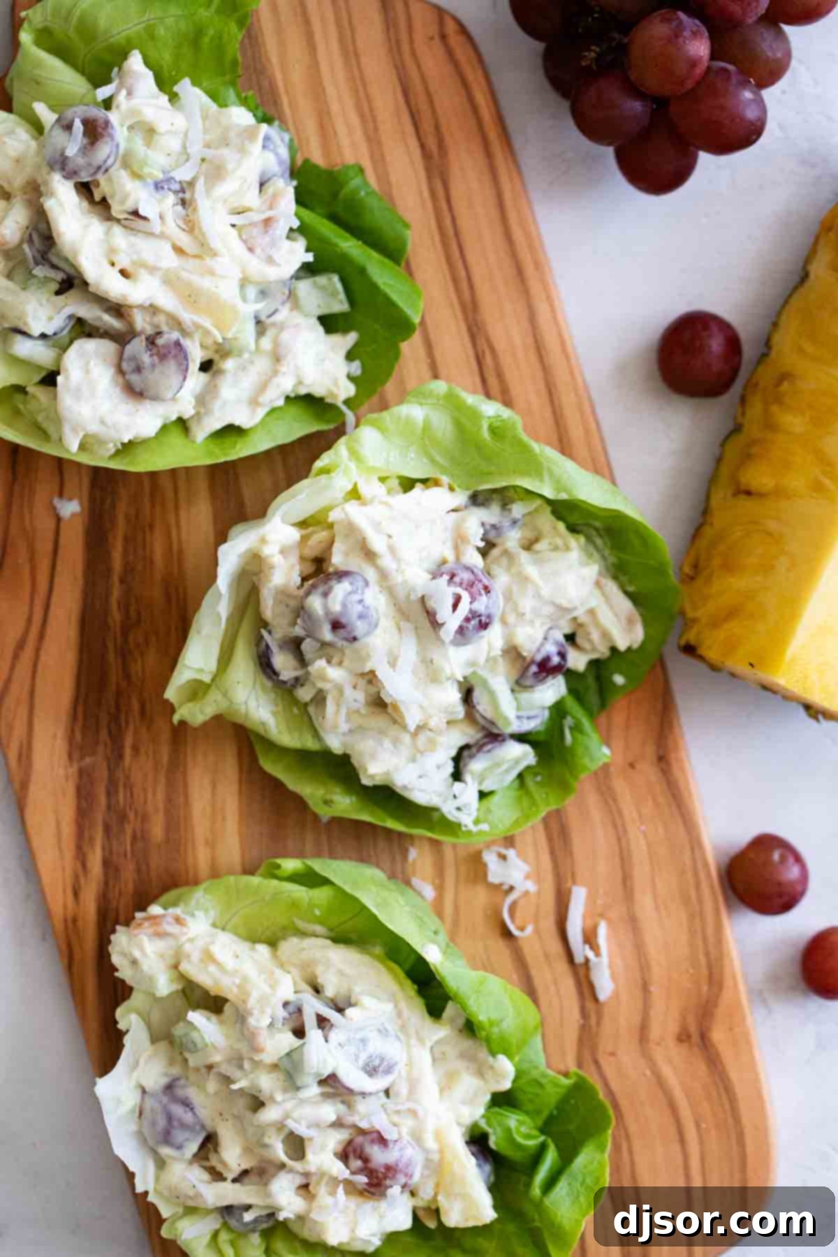 Chicken salad with an island twist - these Tropical Chicken Lettuce Wraps are filled with chicken, pineapple, grapes, and coconut with a creamy sauce to make the perfect perfect lettuce wraps. overhead view of Tropical Chicken Lettuce Wraps
