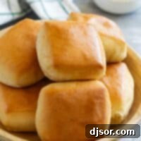 Texas Roadhouse Rolls stacked in a wooden bowl.