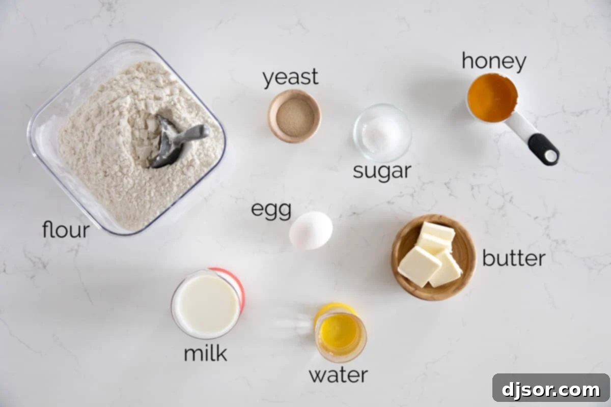 A perfectly arranged photo showcasing all the vital ingredients required to bake Texas Roadhouse Rolls, including milk, butter, water, yeast, sugar, honey, flour, and an egg.