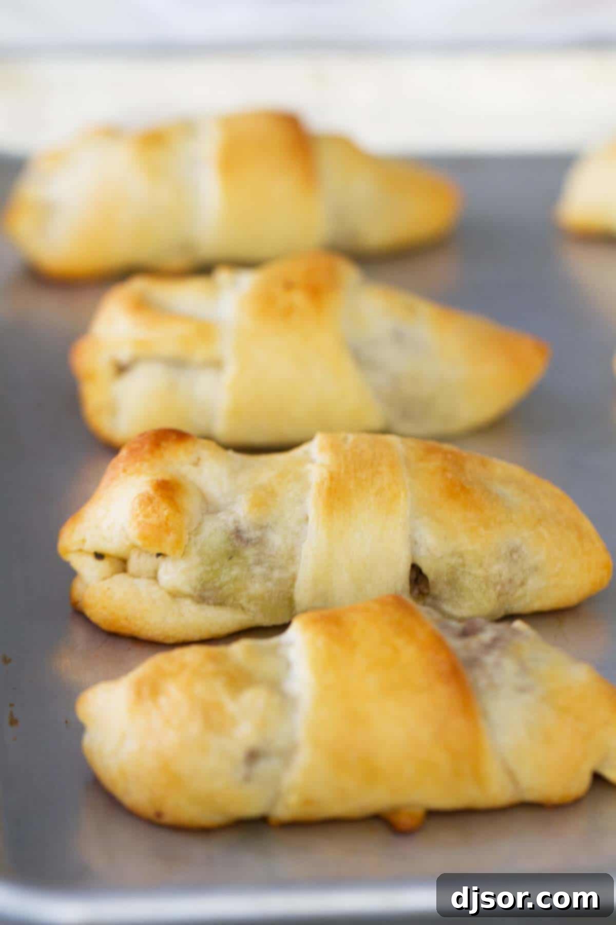 Savory Beef and Cabbage Rolls 4 Close-up of golden-brown Cabbage and Beef Bundles on a baking sheet, showing their flaky texture.