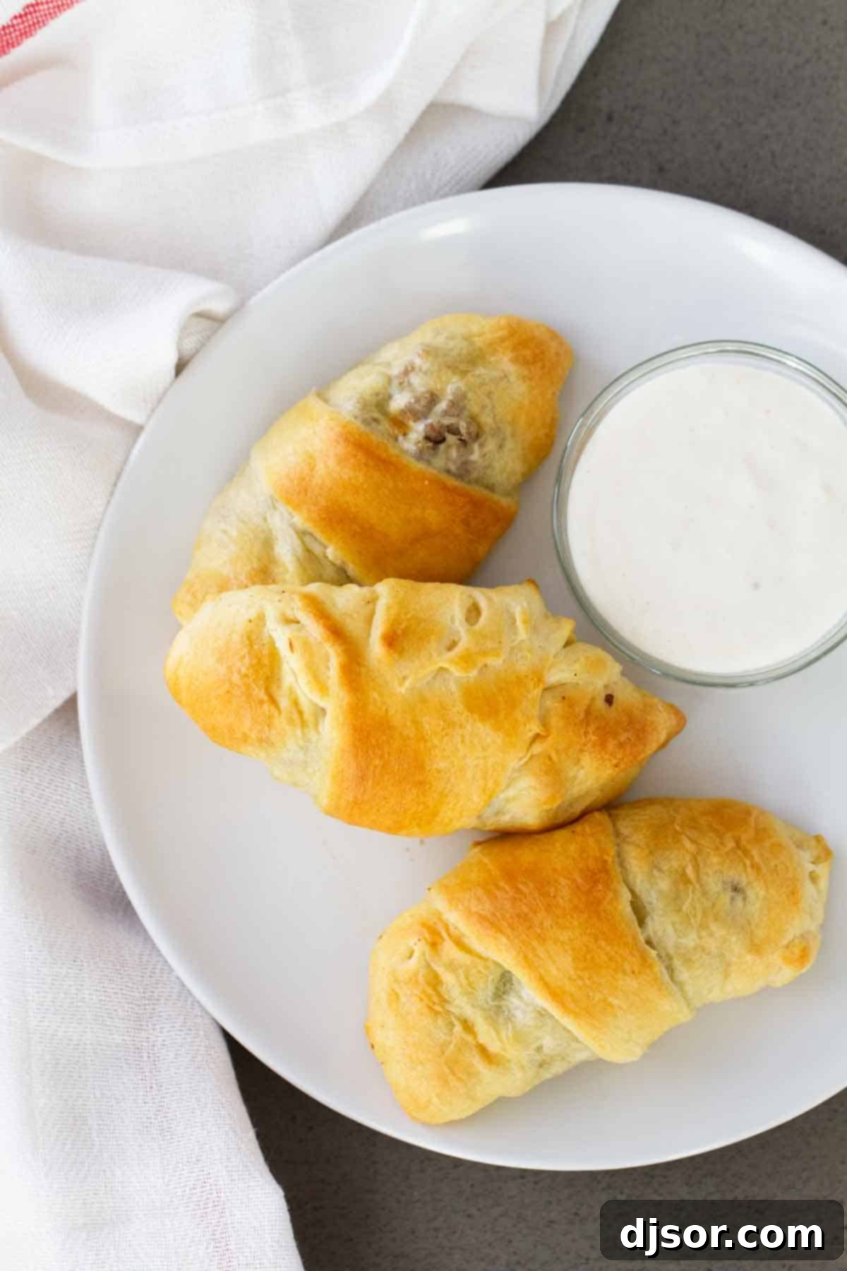 Savory Beef and Cabbage Rolls 5 A single Cabbage and Beef Bundle on a plate, with a dollop of horseradish mayo on the side.