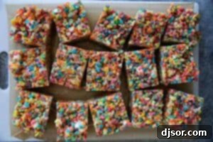 Fruity Pebble Rice Crispy Treats cut into perfect squares, ready to be served.