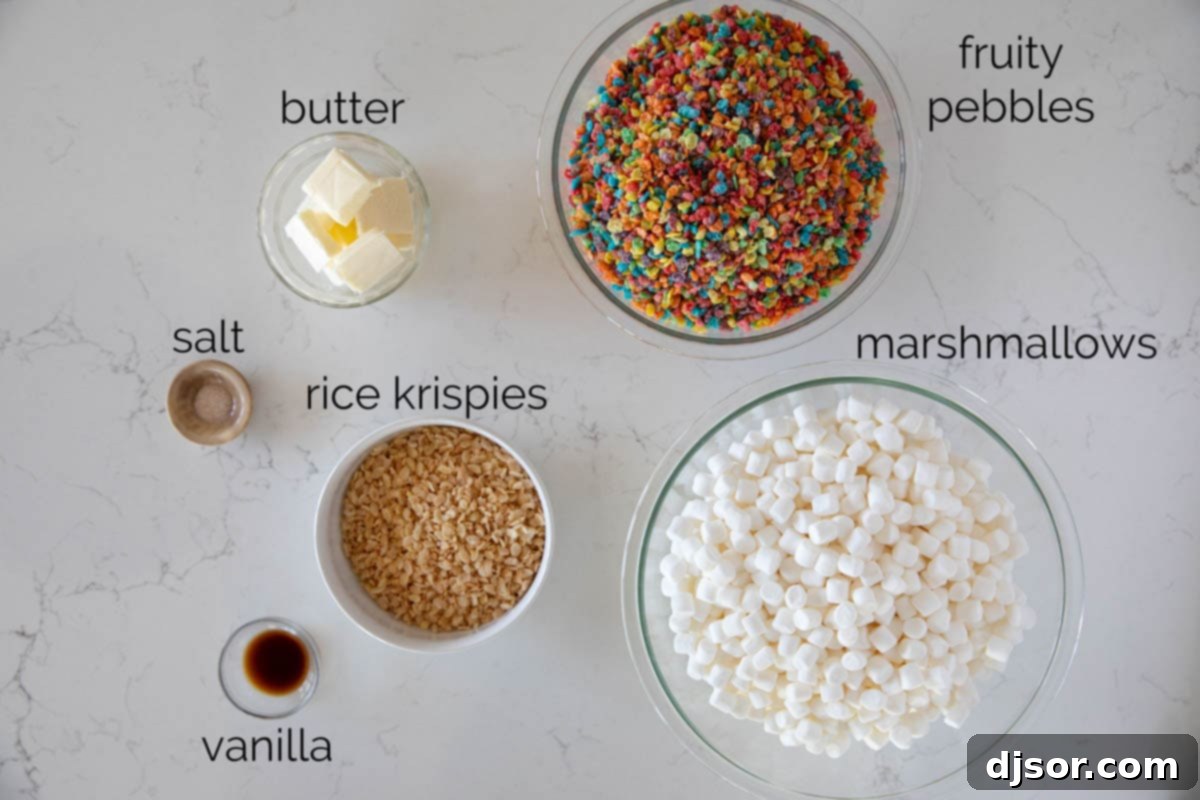 A collection of ingredients laid out on a table, including Fruity Pebbles cereal, Rice Krispies, mini marshmallows, butter, vanilla extract, and sea salt.