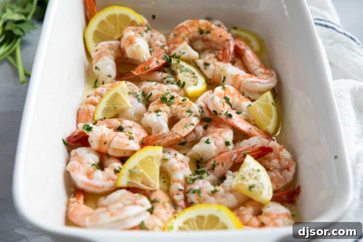 Lemon Garlic Baked Shrimp 2 Baked shrimp in a casserole dish with lemon slices and fresh parsley, ready to be served.