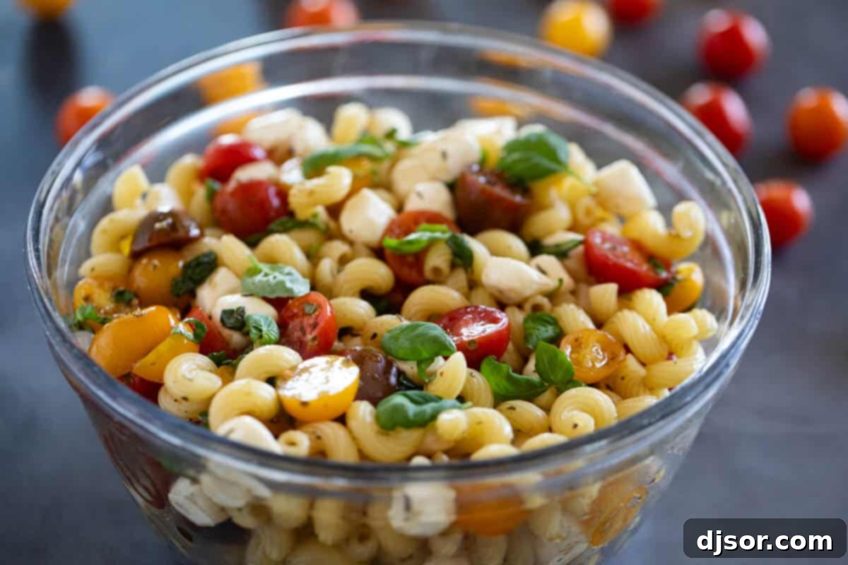 Bowl of Caprese Pasta Salad with fresh tomatoes and basil, ready to be served.