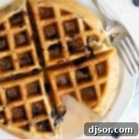 Delicious Blueberry Waffles 2 overhead view of blueberry waffle with syrup with a bite taken