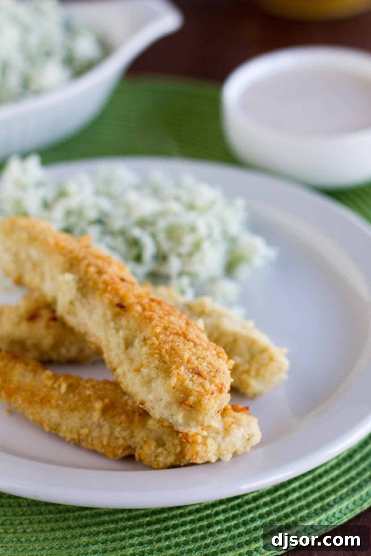 Crispy Tortilla Crusted Chicken Tenders served on a rustic plate with a side of creamy Southwestern Dipping Sauce, garnished with fresh cilantro.