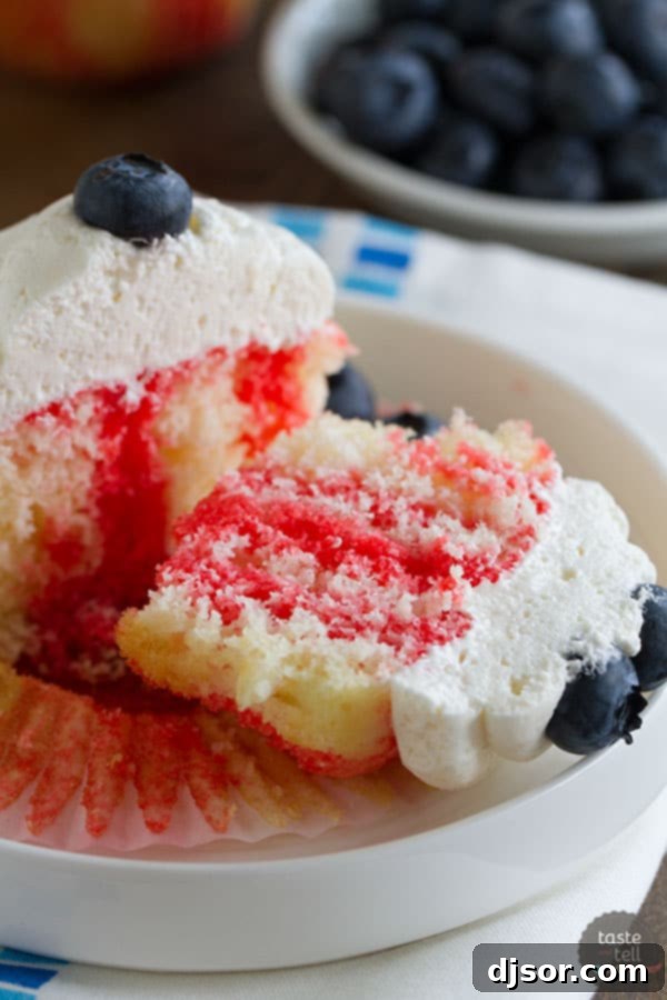 Jiggly Jell-O Poke Cupcakes 5 Jello poke cupcakes adorned with creamy white frosting and ripe blueberries, a delicious and easy dessert for summer holidays.