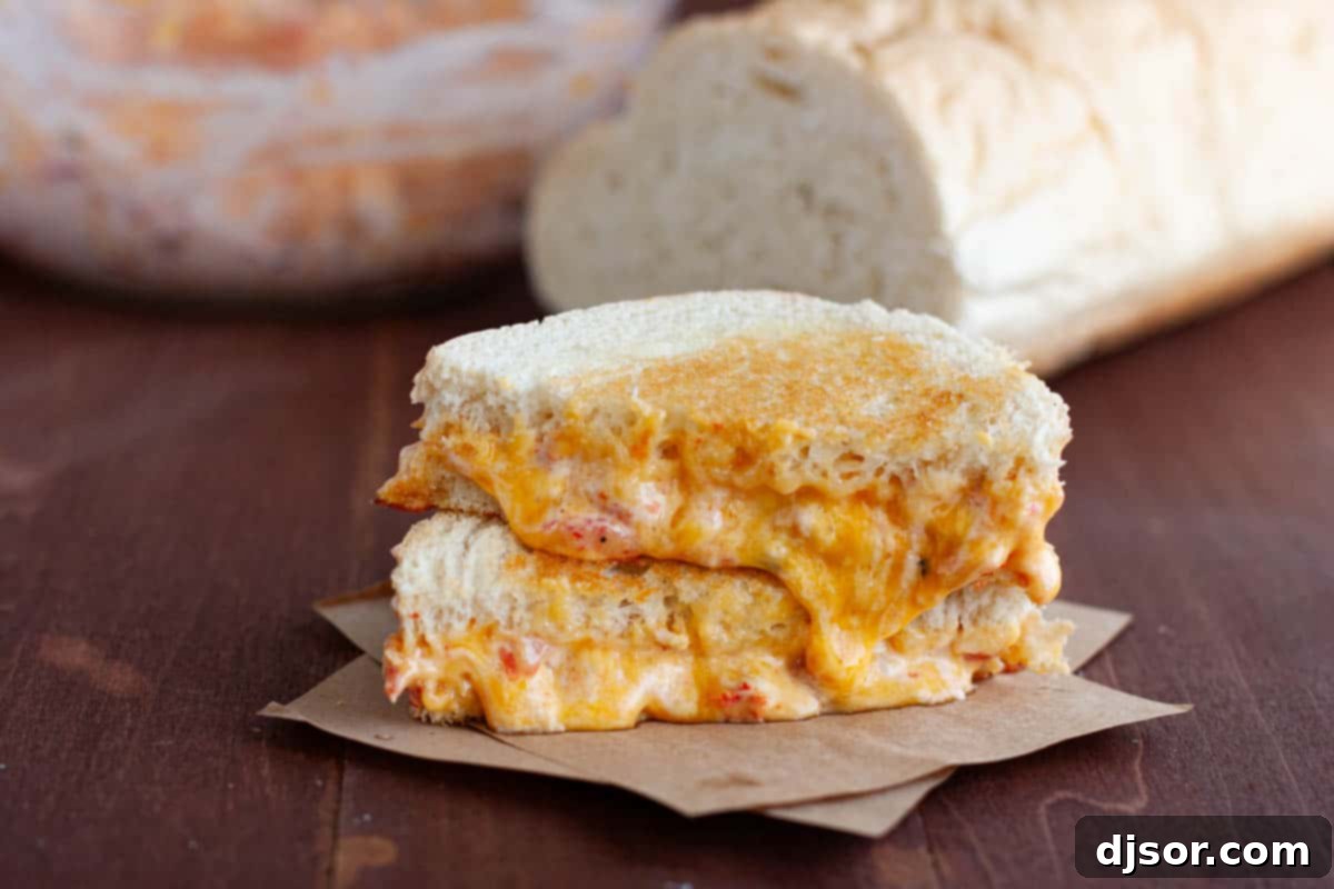 Pimento Grilled Cheese cut in half with cheese oozing out, highlighting its gooey texture.