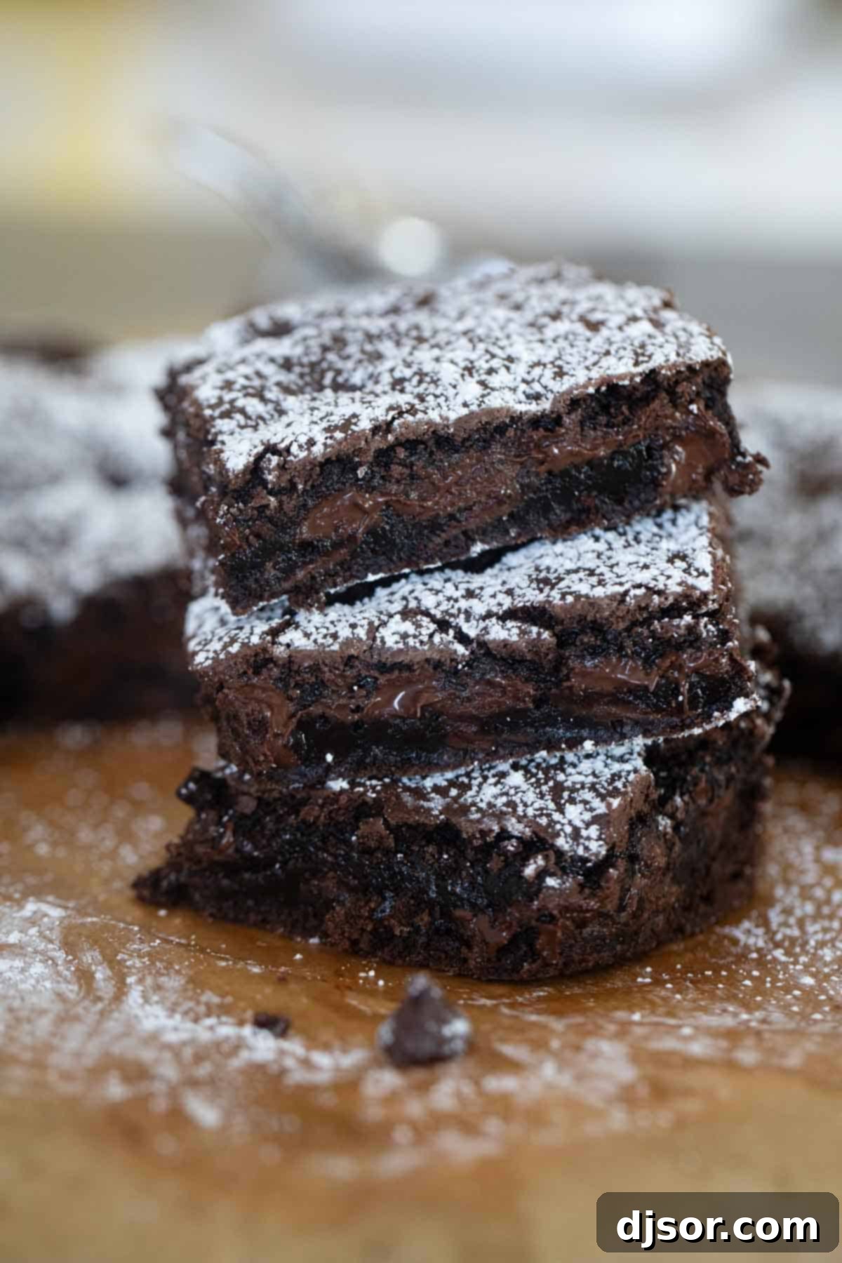 Three perfectly cut cake mix brownies stacked on top of each other, showing a fudgy interior.
