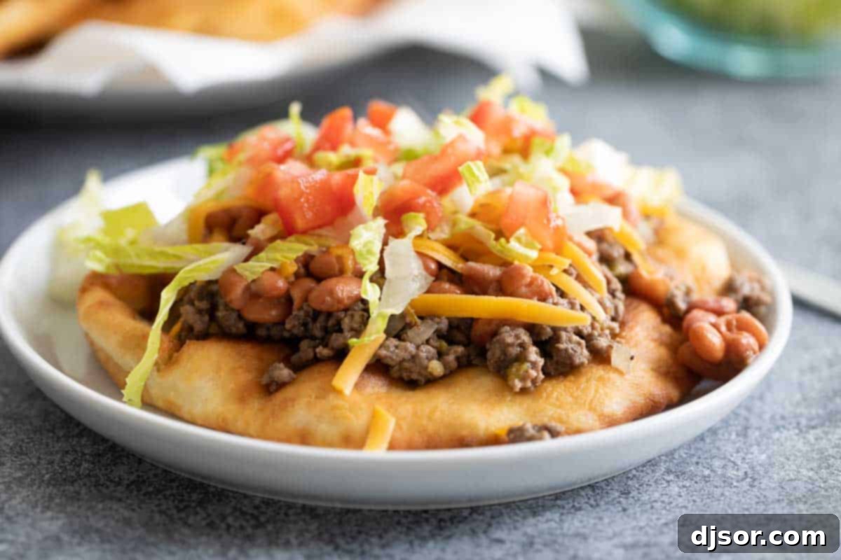 A traditional Navajo Taco – homemade fry bread topped with savory meat, beans, cheese, lettuce and tomatoes. Save any leftover fry bread to enjoy with honey for dessert! Crispy fry bread topped with ground beef, beans, and fresh vegetables for a delicious Navajo Taco meal