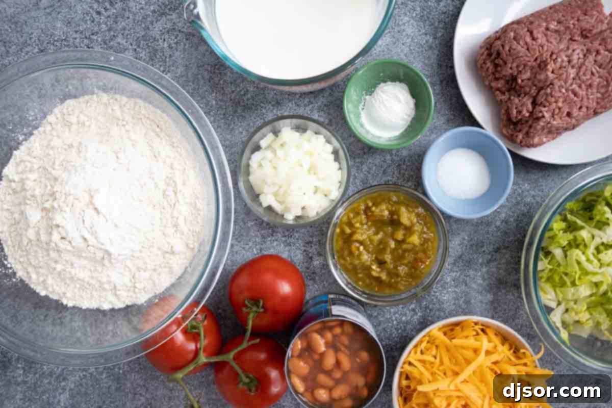 A vibrant display of fresh ingredients, including ground beef, beans, and an assortment of toppings, ready for making Navajo Tacos. Overhead view of all fresh ingredients needed to prepare homemade Navajo Tacos