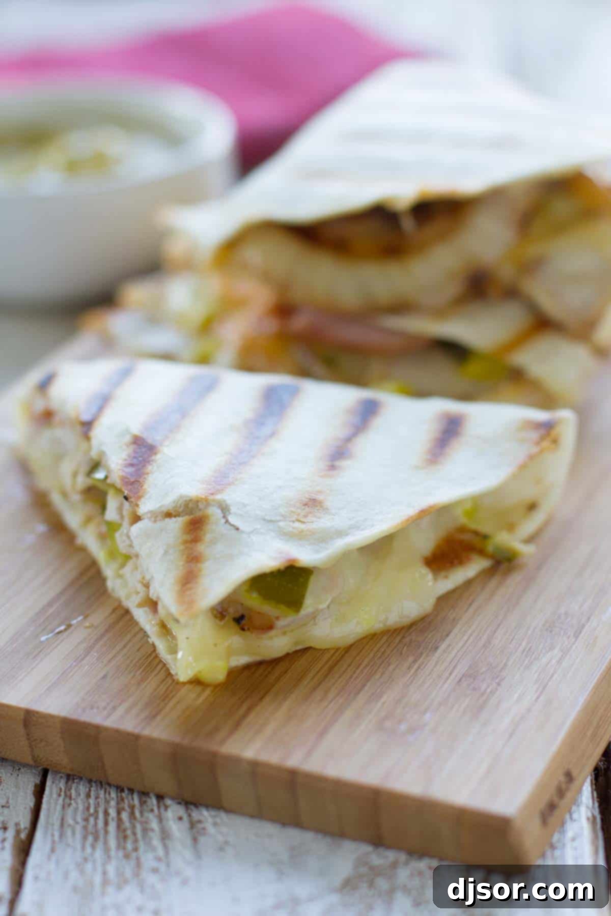 Easy Cuban Quesadilla Delight 2 Sliced Cuban quesadillas revealing the flavorful layers on a wooden cutting board.