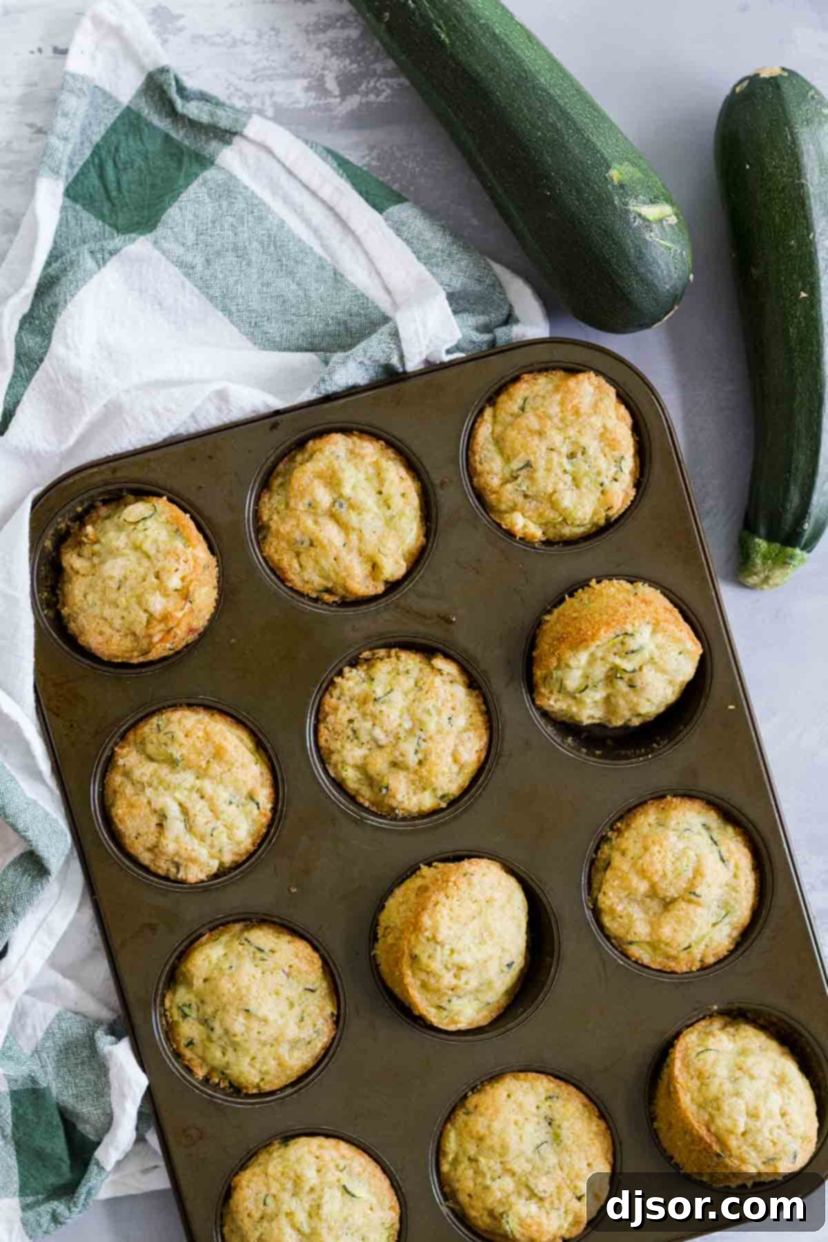 overhead view of Zucchini Muffins in a pan with zucchini on the side