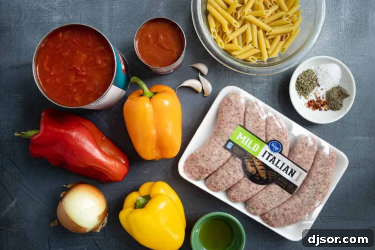 Essential ingredients for creating the delicious Sausage and Peppers Pasta. fresh ingredients laid out on a cutting board, including penne pasta, bell peppers, sausage, onion, and canned tomatoes