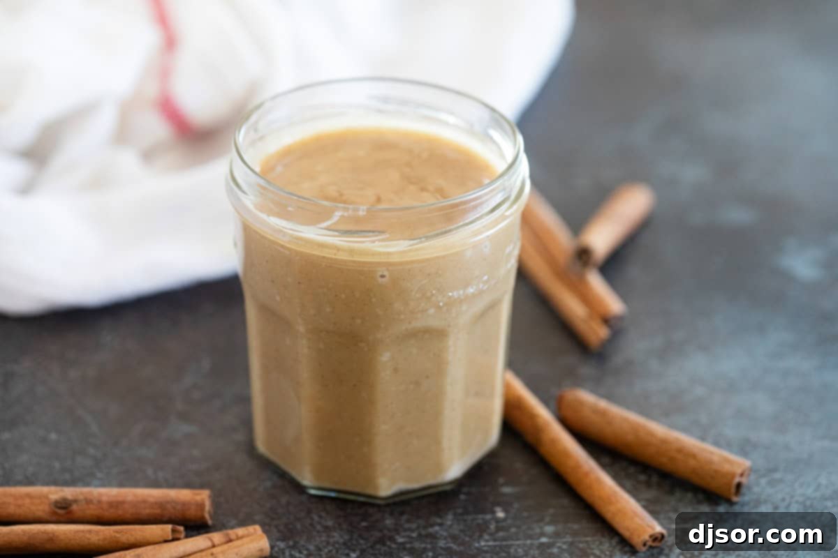 Velvet Cinnamon Nectar 2 Cinnamon Syrup in a small jar with cinnamon sticks next to it.