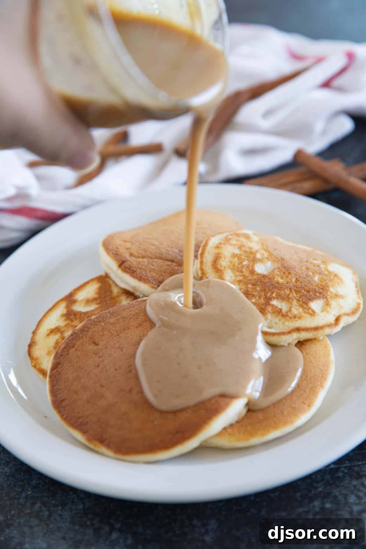 Velvet Cinnamon Nectar 6 Pouring cinnamon syrup onto pancakes.