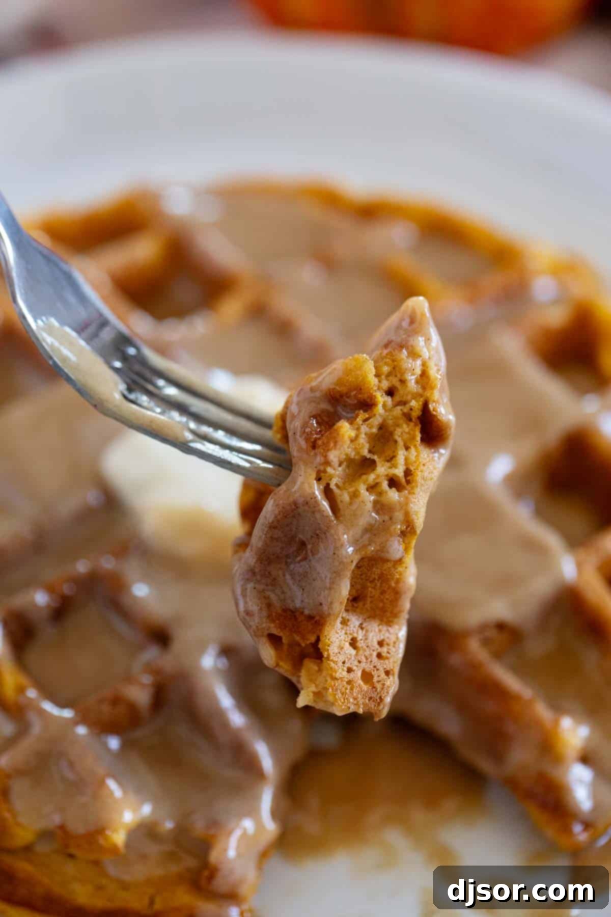 Autumn Pumpkin Waffles 8 A close-up shot of a Pumpkin Waffle on a fork, showing its soft, airy, and creamy interior texture, highlighting the perfect consistency.