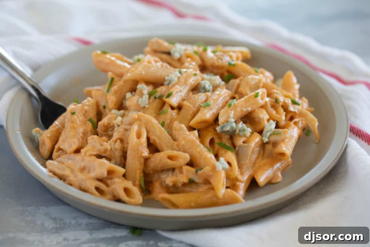 Ultimate Buffalo Chicken Pasta 2 Plate with Buffalo Chicken Pasta, topped with blue cheese and chives.