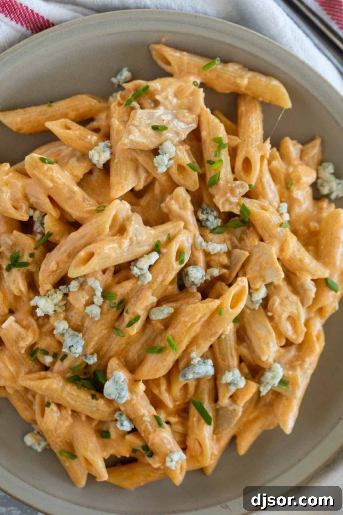 Ultimate Buffalo Chicken Pasta 9 Plate filled with buffalo chicken pasta topped with blue cheese.